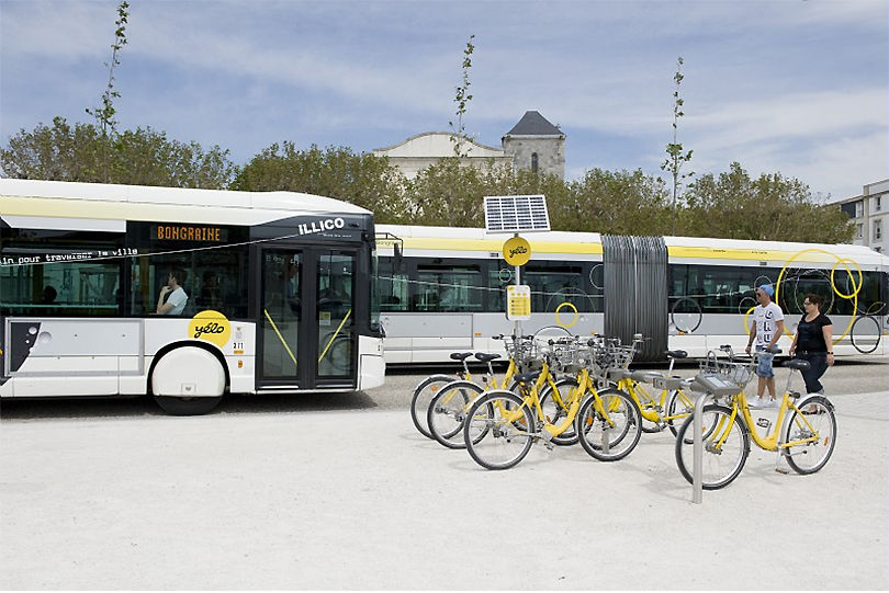 프랑스 도시 라로쉘의 공공운송회사인 옐로의 버스와 자전거 여러 대가 주차되어 있는 사진