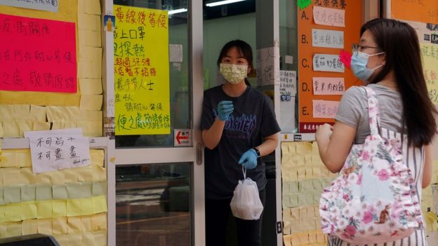 홍콩 '사회적 거리두기'를 지키려고 마스크를 끼고 포장 음식을 파는 직원과 음식을 사가려고 기다리고 있는 고객